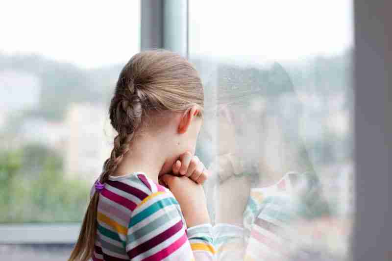 worried girl looking out window