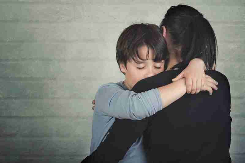 Mother hugging worried child