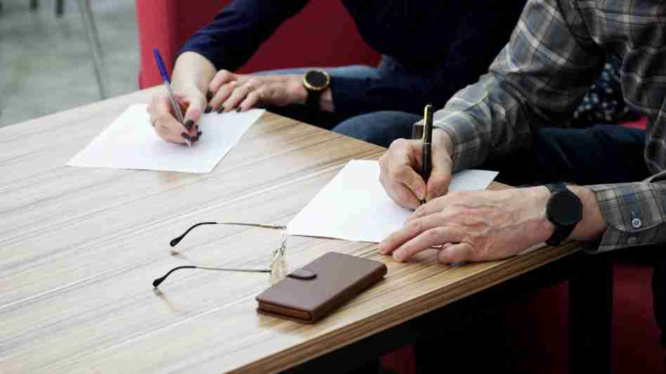 man and woman signing legal papers