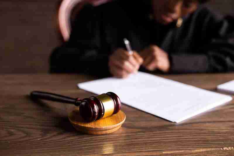 judge signing papers on desk