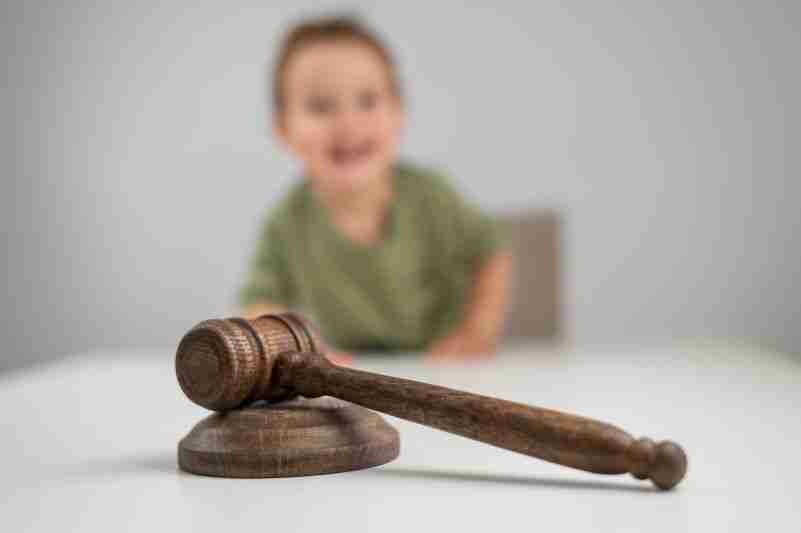 blurred child behind gavel